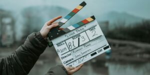 Close-up of a film clapperboard on an outdoor set, signaling scene start.